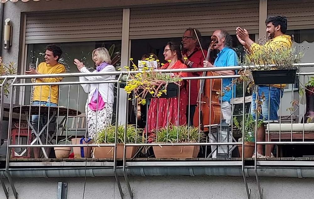 Mitglieder des Ensembles stehen auf dem Balkon