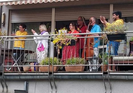 Mitglieder des Ensembles stehen auf dem Balkon