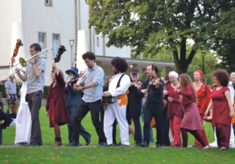 Musiker*innen ziehen musizierend durch den Bielefelder Bürgerpark